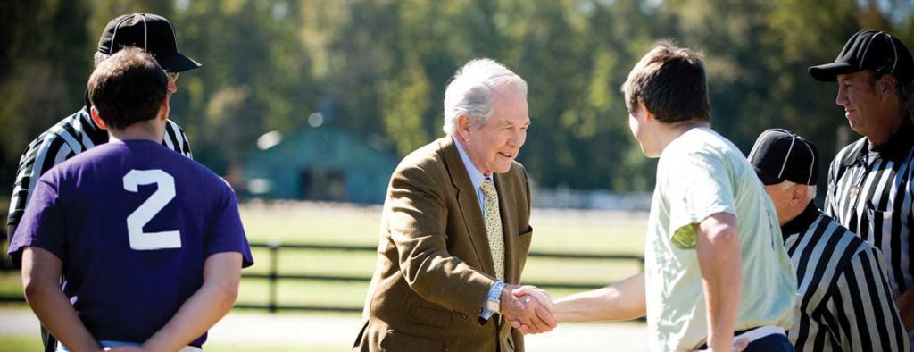 Dr. M.G. "Pat" Robertson shaking hands with student at the Regent University Chilli Bowl.